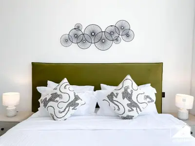 a bed with white pillows and a green headboard at Modern 1B Luxury , Scenic City Balcony, Pool & Gym in Dubai