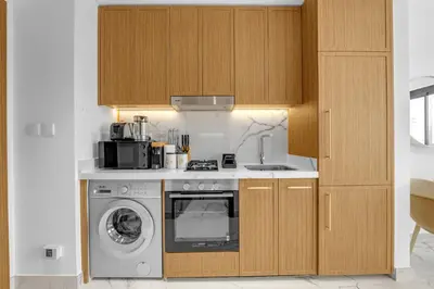 a kitchen with a washing machine and a microwave at Vibrant Studio Your Perfect Stay Awaits in Dubai