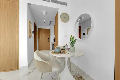 a dining room with a table and chairs and a mirror at Vibrant Studio Your Perfect Stay Awaits in Dubai