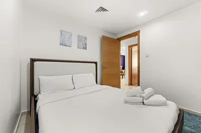 a bedroom with a large white bed with two pillows at Golden Woods Escape Near Marina & JBR in Dubai