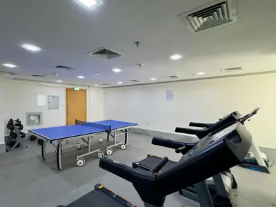 a gym with a ping pong table and cardio equipment at Golden Woods Escape Near Marina & JBR in Dubai