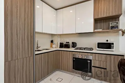 a kitchen with white cabinets and a microwave at Stylish 1 bedroom in Pinnacle, Dubai Hills in Dubai