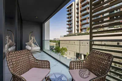 a balcony with two chairs and a large window at Stylish 1 bedroom in Pinnacle, Dubai Hills in Dubai