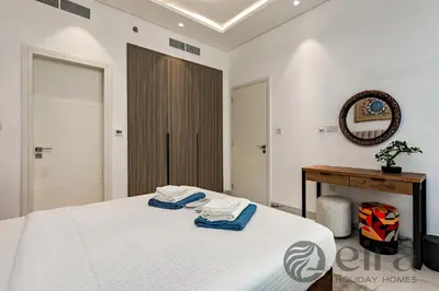 a bedroom with a bed and a table and a mirror at Stylish 1 bedroom in Pinnacle, Dubai Hills in Dubai
