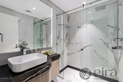 a bathroom with a sink and a glass shower at Stylish 1 bedroom in Pinnacle, Dubai Hills in Dubai