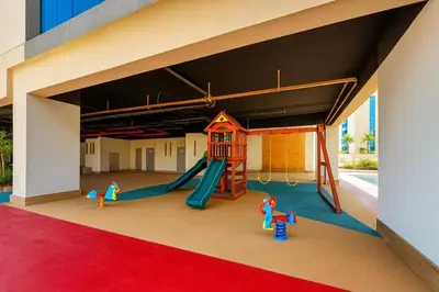 a playground with a slide and play equipment in a building at Vogue Jeewar JVC near Circle Mall, One Bedroom Apartment with Balcony and Park view, Access to all Amenities in Dubai
