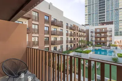 an apartment balcony with a pool and buildings at Vacationer l Upgraded 1 Bedroom l near Circle Mall in Dubai