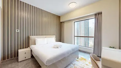 a bedroom with a white bed and a large window at Rimal - Upgraded Three Plus Kids Bedroom in JBR in Dubai