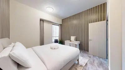 a white bedroom with a white bed and a window at Rimal - Upgraded Three Plus Kids Bedroom in JBR in Dubai