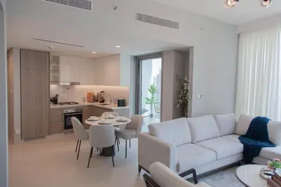 a living room with a white couch and a table and chairs at Royal suites LIv Marina views in Dubai