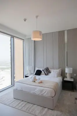 a bedroom with a large white bed with a large window at Royal suites LIv Marina views in Dubai