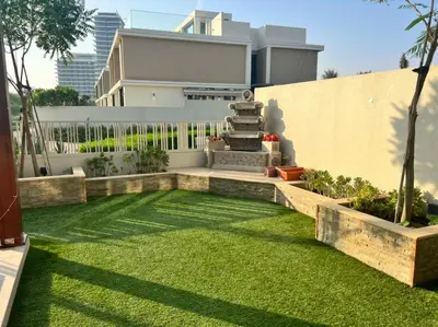a garden with green grass in front of a building at Room for rent in a luxury villa in Dubai