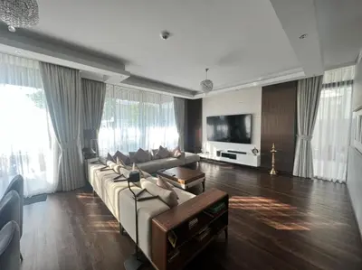a living room with a couch and a tv at Room for rent in a luxury villa in Dubai