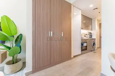 a living room with a sliding door in a kitchen at Close to Meydan Racecourse and Ras Al Khor Wildlife Sanctuary, And a Quick Drive to Downtown Dubai and the Iconic Burj Khalifa - Azizi Riviera 44, Meydan by Deluxe Holiday Homes in Dubai