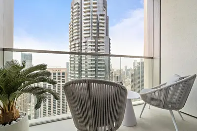 a room with two chairs and a large window at VayK - Stunning 2BR Apt with 2 Balconies in Downtown in Dubai