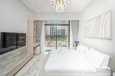 a white bedroom with a bed and a large window at Modern Studio Apartment for Rent Fully Furnished in Dubai