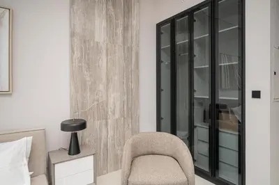 a bedroom with a chair next to a bed at Modern Studio Apartment for Rent Fully Furnished in Dubai