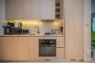 a kitchen with white cabinets and an oven at Modern Studio Apartment for Rent Fully Furnished in Dubai