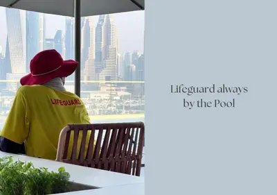 a person sitting on a bench looking out a window at a city at Elegant 1BHK Dubai Private Beachfront in Dubai