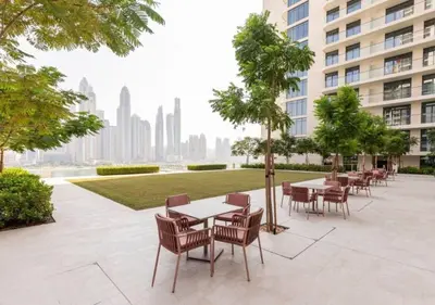 a patio with tables and chairs in a building at Elegant 1BHK Dubai Private Beachfront in Dubai