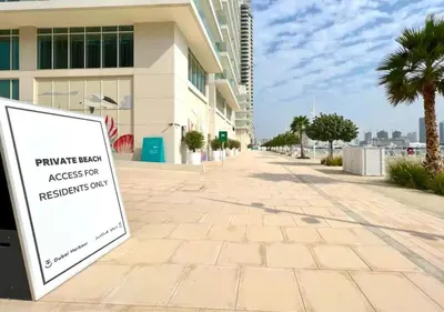 a sign on a sidewalk in front of a building at Elegant 1BHK Dubai Private Beachfront in Dubai
