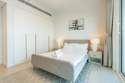 a bedroom with a bed with two towels on it at Magical La Vie JBR Apt with Private Beach Access in Dubai
