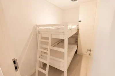 a bunk bed in a small room with a ladder at Magical La Vie JBR Apt with Private Beach Access in Dubai