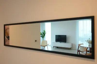 a mirror hanging on a wall in a living room at Magical La Vie JBR Apt with Private Beach Access in Dubai