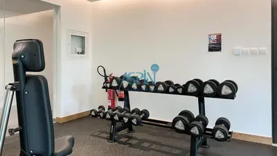 a room with a gym with a rack of weights at Aspin Modern Studio Apartment in AHAD Residency in Dubai