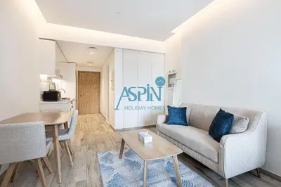 a living room with a couch and a table at Aspin Modern Studio Apartment in AHAD Residency in Dubai