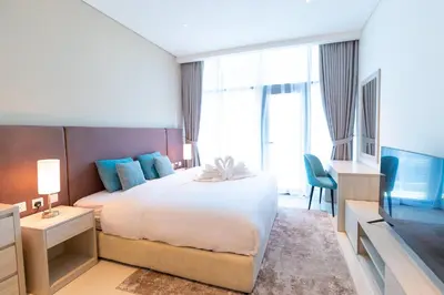 a hotel room with a large bed and a television at Seven Palm Studio - Direct Beach Access- Rooftop Infinity Pool in Dubai