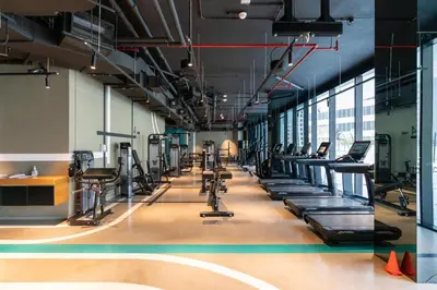 a gym with rows of treadmills and machines at GuestReady - Canal View Studio | Near Downtown in Dubai