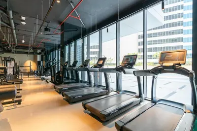 a row of treadmills in a gym with windows at GuestReady - Canal View Studio | Near Downtown in Dubai