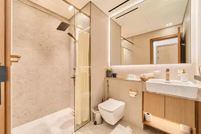 a bathroom with a shower and a toilet and a sink at Modern 2BR Retreat in JVC with Private Pool Balcony in Dubai
