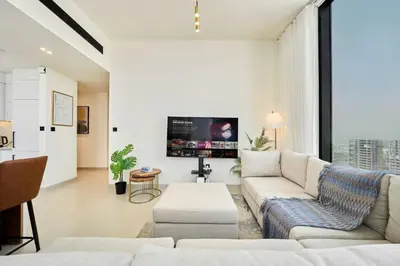 a living room with a couch and a tv at Modern 2BR Retreat in JVC with Private Pool Balcony in Dubai