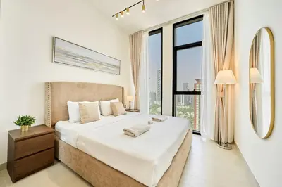 a bedroom with a large bed and a large window at Modern 2BR Retreat in JVC with Private Pool Balcony in Dubai