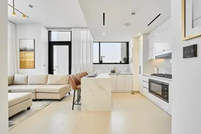 a living room with a couch and a table at Modern 2BR Retreat in JVC with Private Pool Balcony in Dubai