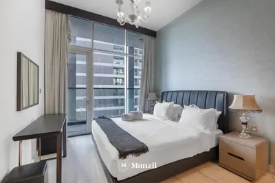 a bedroom with a large bed and a large window at Luxury 2BR Apartment in Business Bay with Pool, Sauna and Burj Khalifa View in Dubai