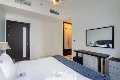 a bedroom with a bed with a table and a mirror at Luxury 2BR Apartment in Business Bay with Pool, Sauna and Burj Khalifa View in Dubai