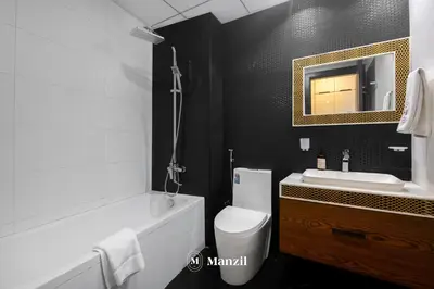 a bathroom with a tub and a toilet and a sink at Luxury 2BR Apartment in Business Bay with Pool, Sauna and Burj Khalifa View in Dubai