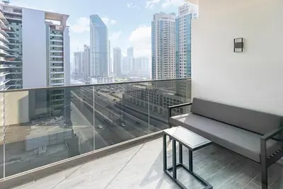 a balcony with a bench and a view of a city at FAM Living - Urban Stays - MAG318, 5 mins to Burj Khalifa in Dubai