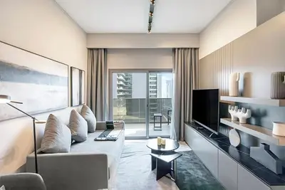 a living room with a couch and a tv at FAM Living - Urban Stays - MAG318, 5 mins to Burj Khalifa in Dubai