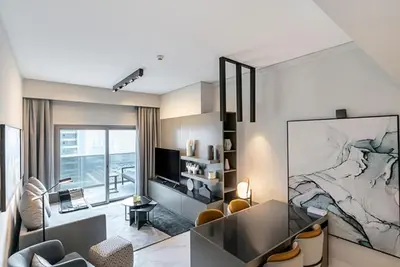 a living room with a large painting on the wall at FAM Living - Urban Stays - MAG318, 5 mins to Burj Khalifa in Dubai