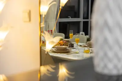 a dining room table with plates and wine glasses at Serene 2BR Burj Khalifa & Fountain View in Dubai