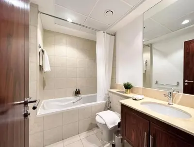 a bathroom with a tub and a toilet and a sink at Serene 2BR Burj Khalifa & Fountain View in Dubai