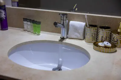 a bathroom sink with a faucet on a counter at Serene 2BR Burj Khalifa & Fountain View in Dubai