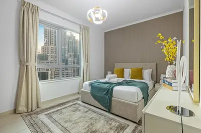 a bedroom with a bed and a large window at Serene 2BR Burj Khalifa & Fountain View in Dubai