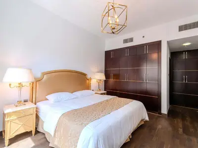 a bedroom with a large bed with a wooden headboard at Luxury in Dubai Marina 1BR beside Vida Yacht Club in Dubai
