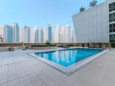 a swimming pool in front of a building with tall buildings at Luxury in Dubai Marina 1BR beside Vida Yacht Club in Dubai