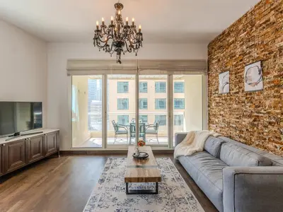 a living room with a couch and a brick wall at Luxury in Dubai Marina 1BR beside Vida Yacht Club in Dubai